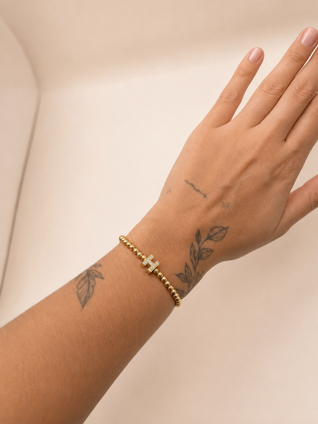 Elastisch H armbandje goud