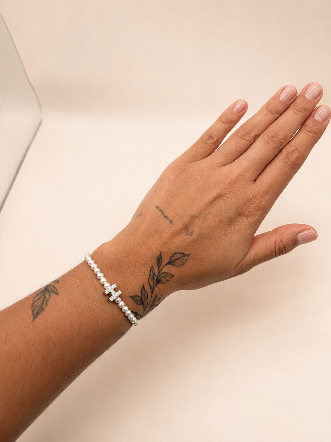 Elastisch H armbandje met parels zilverkleurig