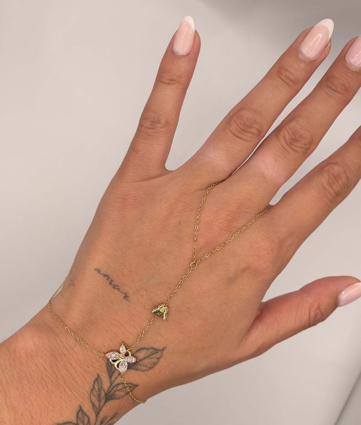 Hand chain met vlinder roze goudkleurig
